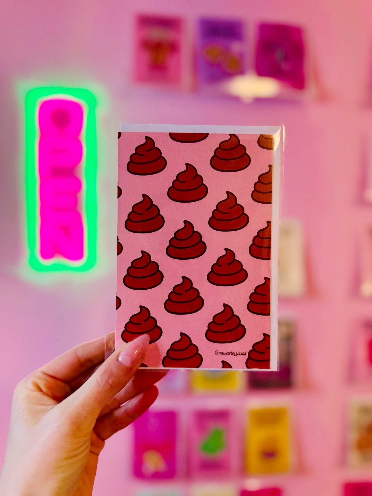 Greeting card featuring a repeating cartoon poop swirl pattern on a soft pink background in a minimalist novelty style.