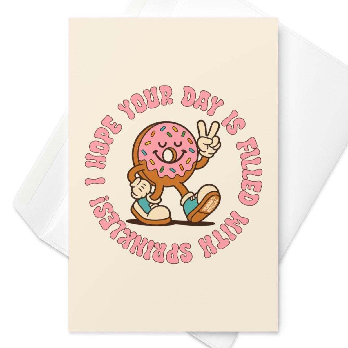 Cream birthday card featuring retro pink frosted donut with sprinkles flashing peace sign and circular birthday text.