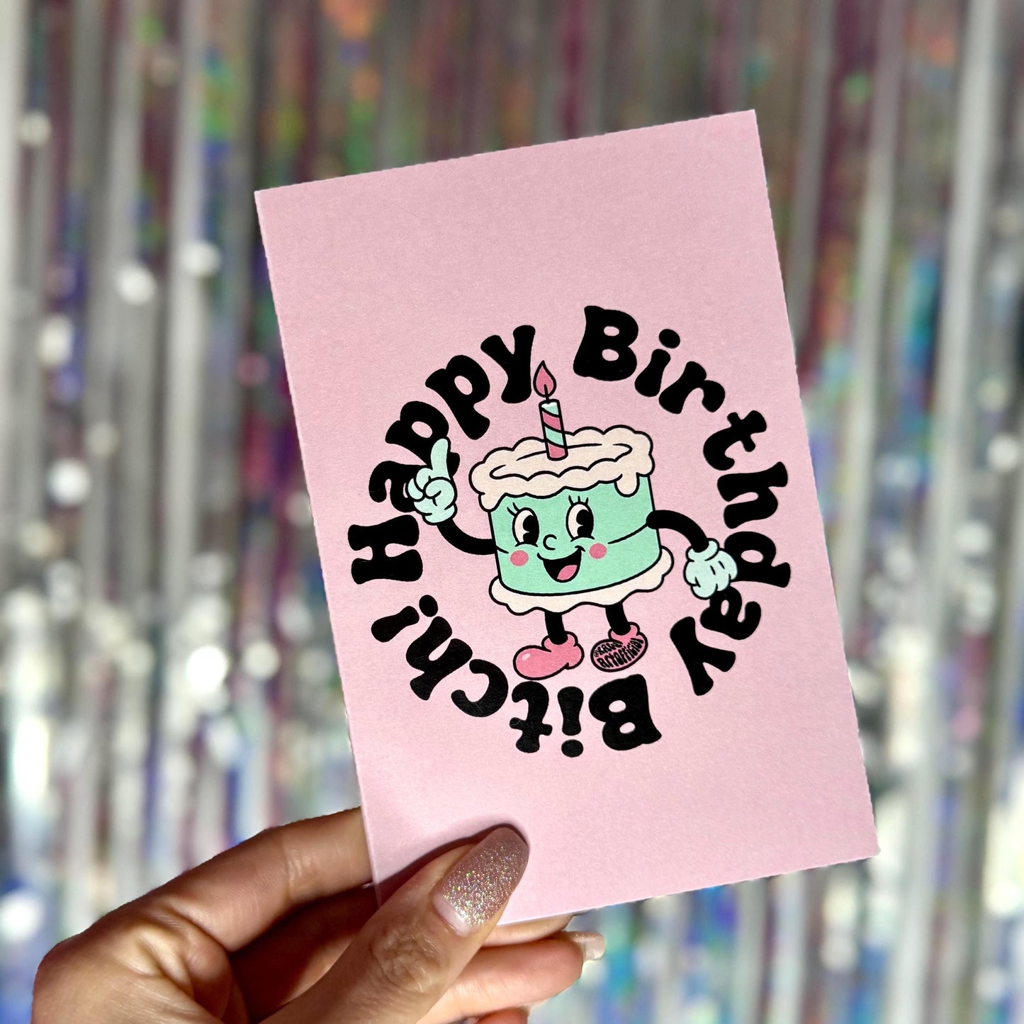 Pink birthday card featuring retro cake with circular text reading “Happy Birthday Bitch.”