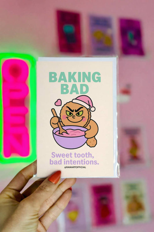 Funny Christmas card with mischievous gingerbread character baking and text “Baking Bad Sweet tooth bad intentions.”