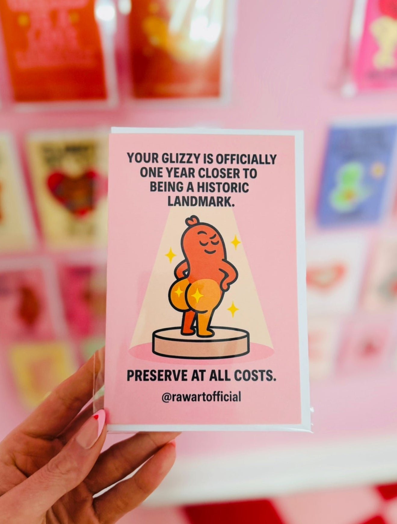 Funny birthday card with cartoon hot dog glizzy displayed like a historic landmark on a pink background