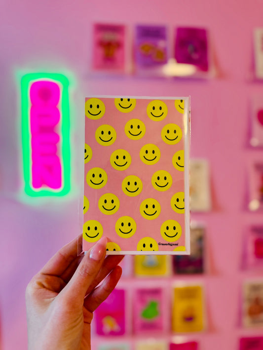 Retro pink greeting card with bold yellow smiley face pattern, playful and fun.