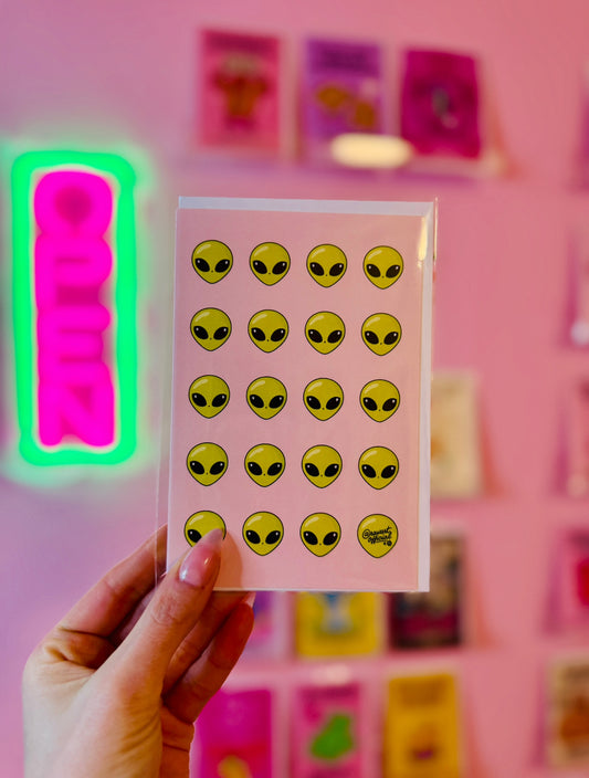 pink card with repeating green alien heads cute space pattern design