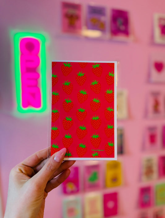 Retro strawberry greeting card with bold red strawberries on hot pink background, playful fruit stationery design.