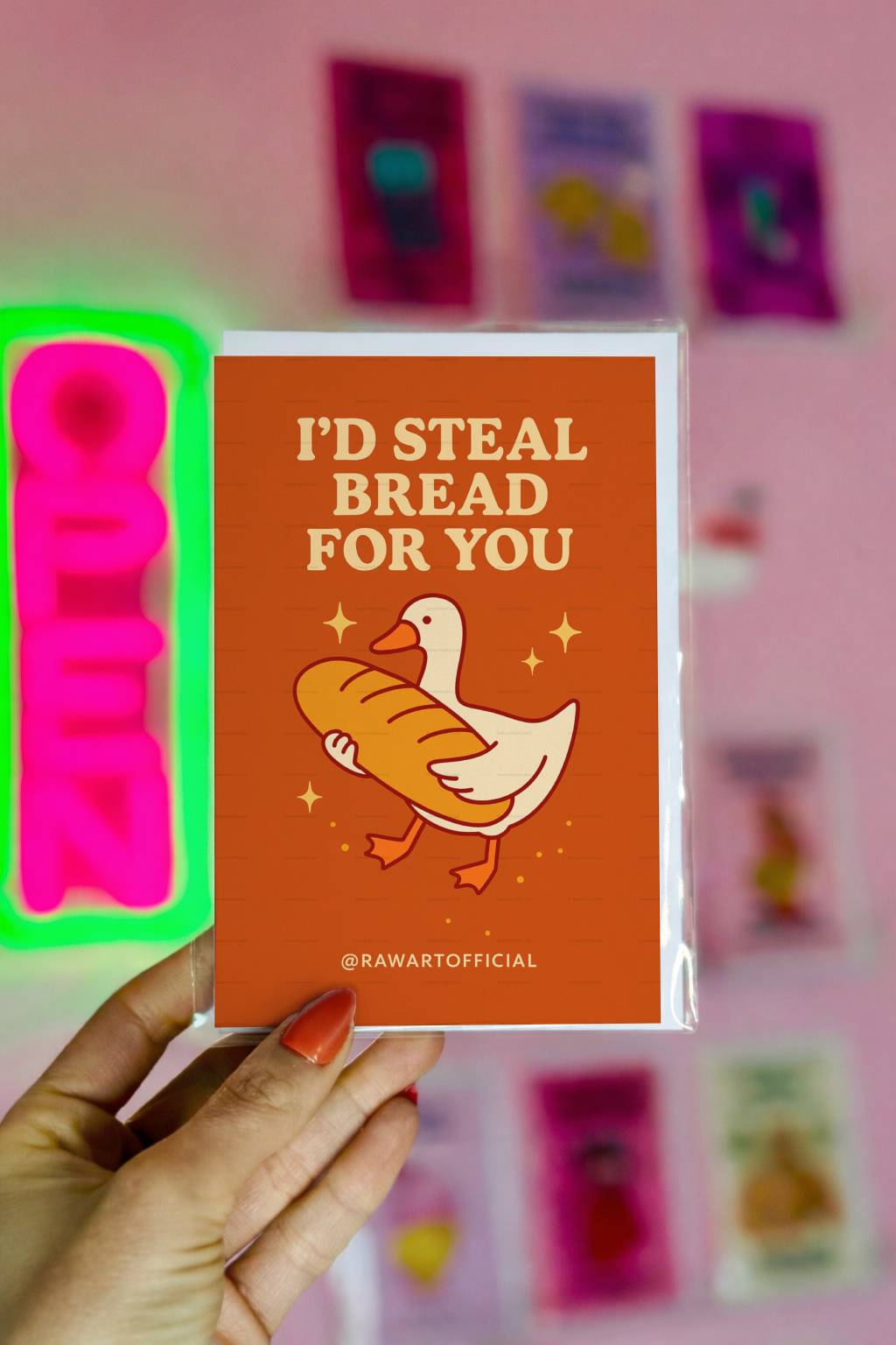 Burnt Orange greeting card with goose holding large baguette and text I’d Steal Bread For You with @rawartofficial signature.