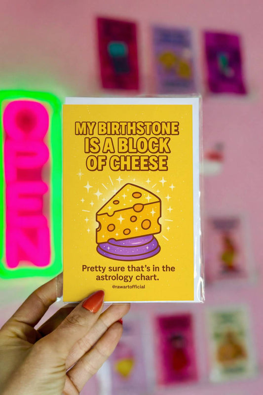 Sparkly cartoon cheese wedge on yellow background with text “My Birthstone Is a Block of Cheese.”
