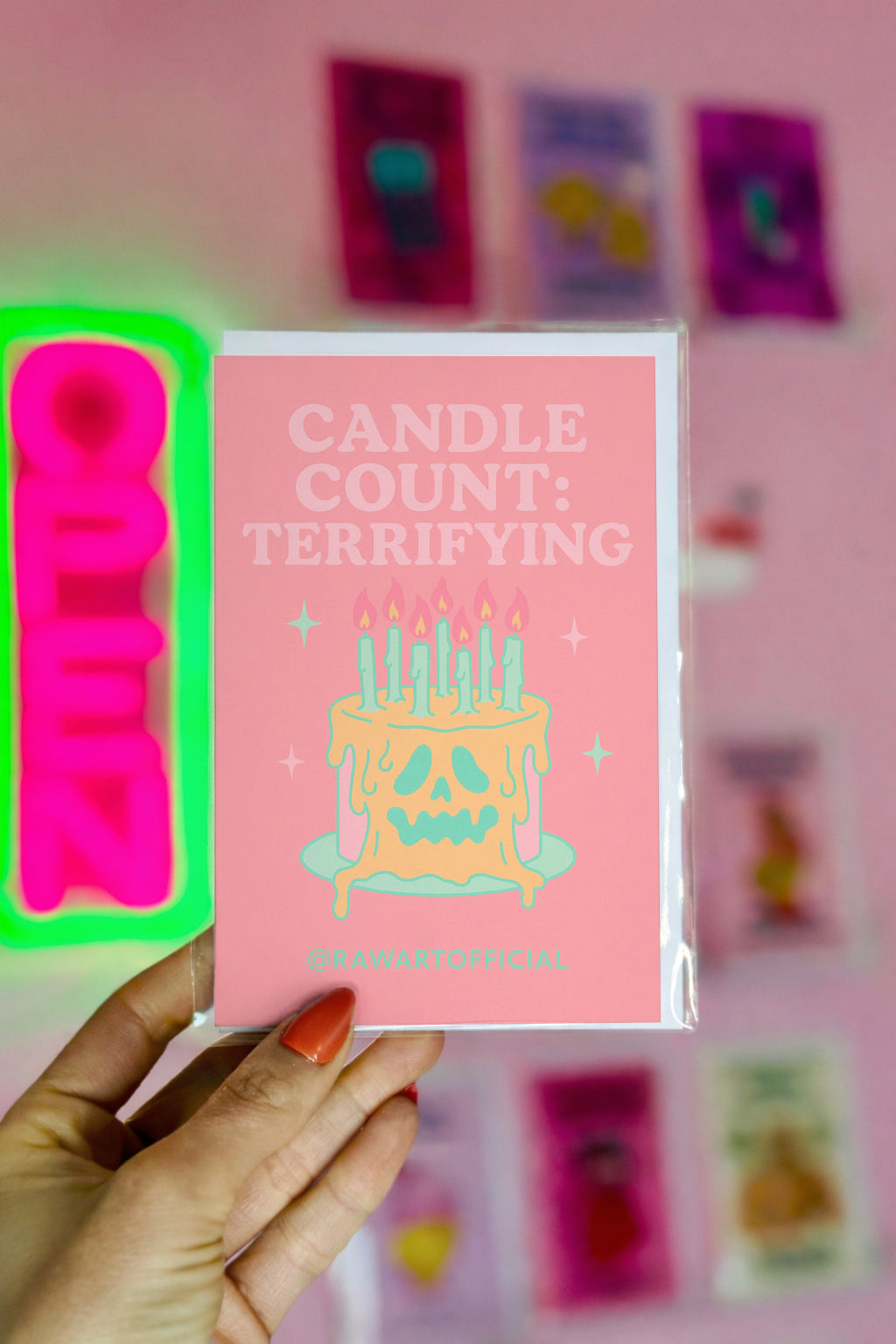 Pink greeting card that reads ‘CANDLE COUNT: TERRIFYING’ above a melting skull-faced birthday cake with many lit mint candles and sparkles—spooky, pastel-goth vibe.