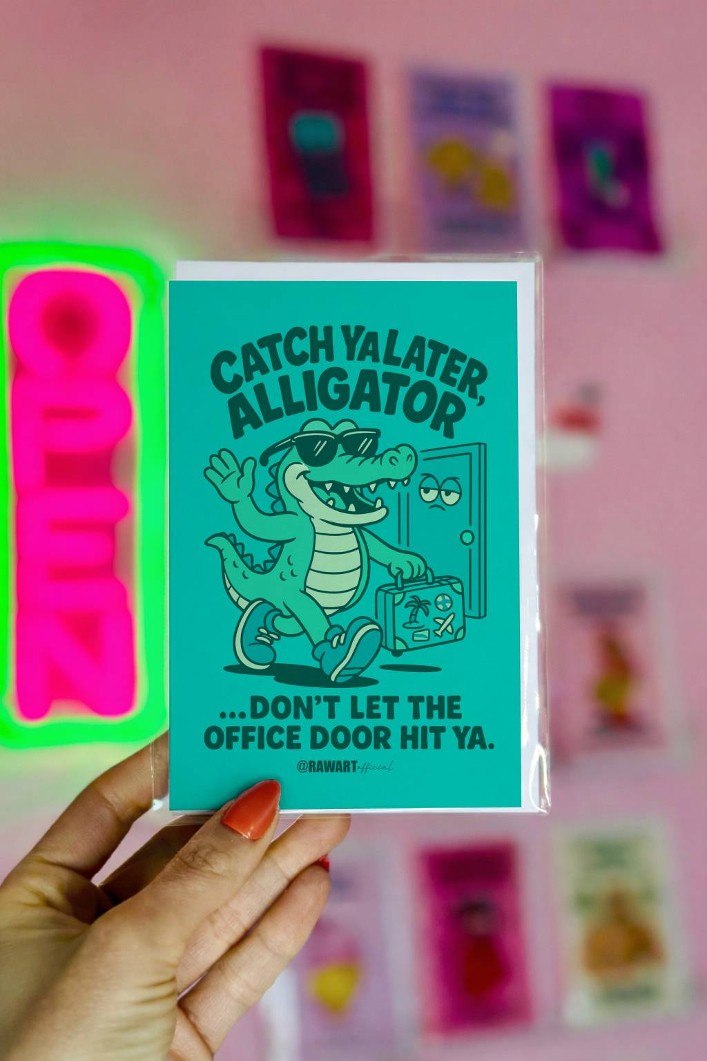 Greeting card featuring a cartoon alligator with a suitcase leaving an office door with the text “Catch Ya Later, Alligator.”