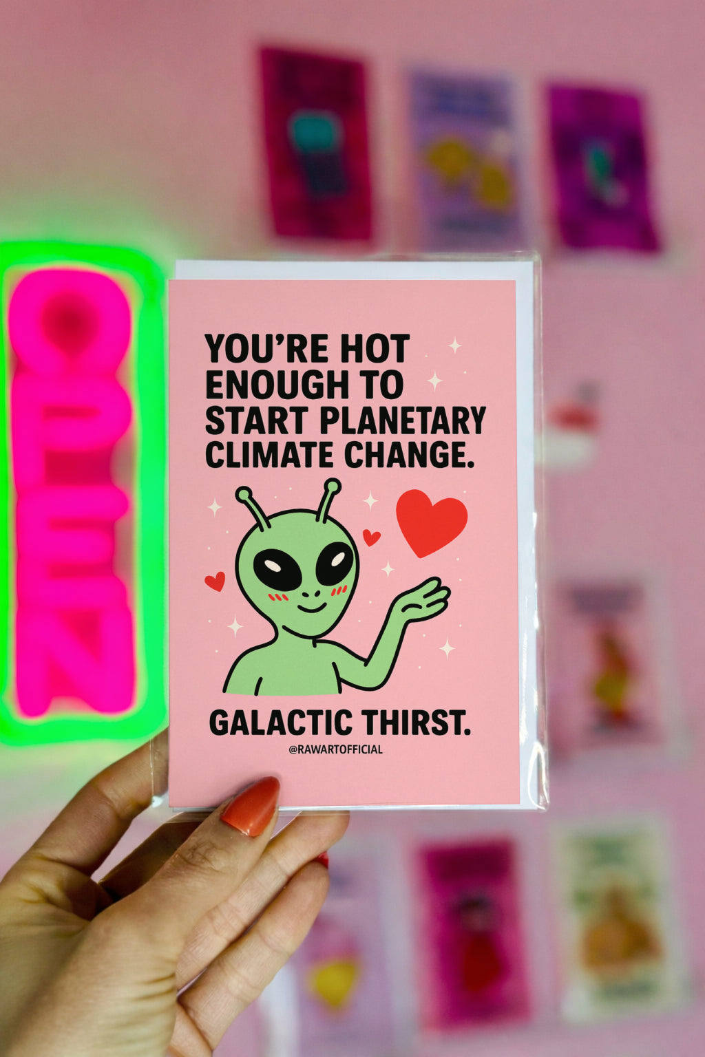 Blushing alien with hearts and sparkles on a pink background, text saying “You’re hot enough to start planetary climate change.”