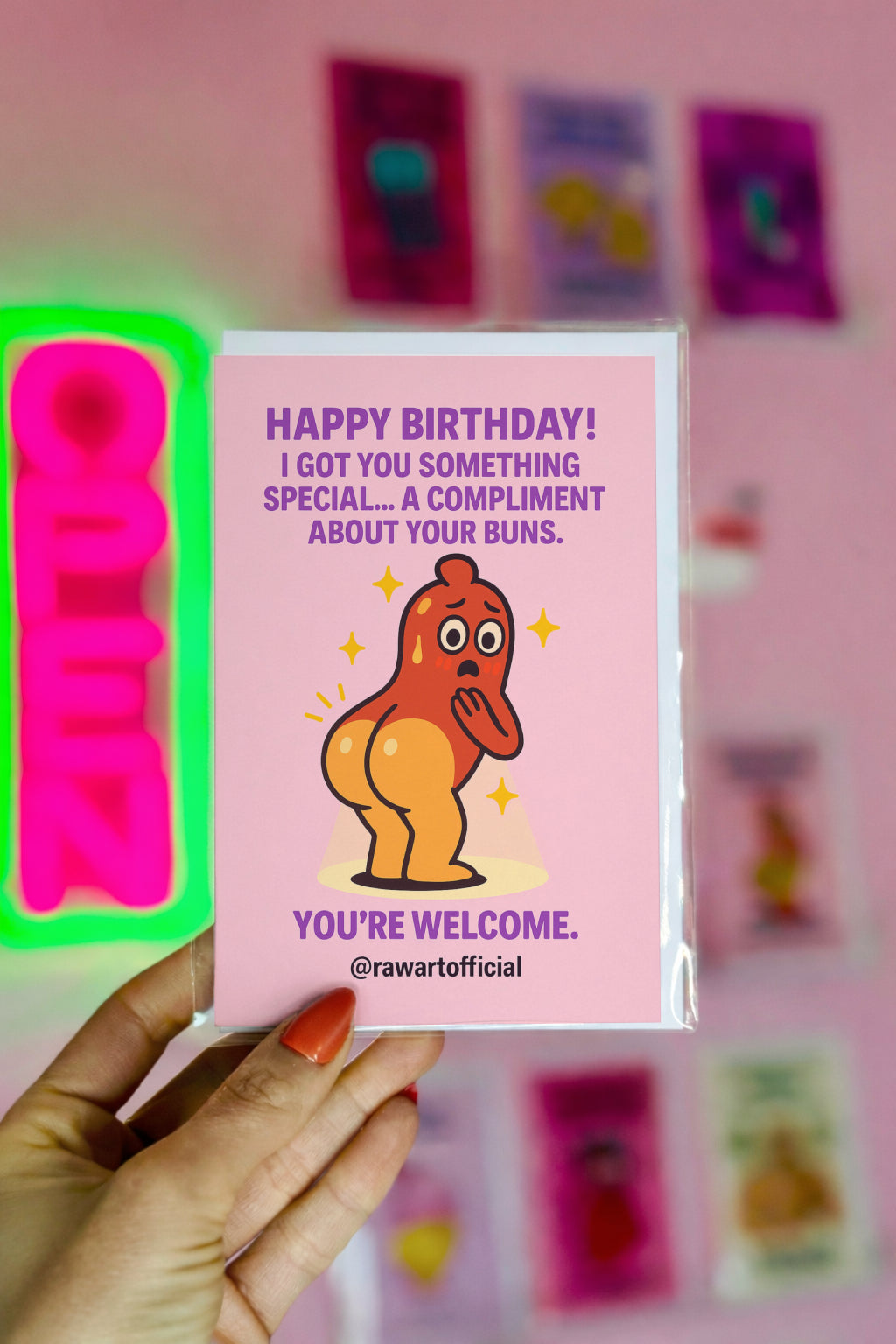 Funny birthday card featuring a cute cartoon hot dog character with shiny buns, playful compliment text, and pink background.