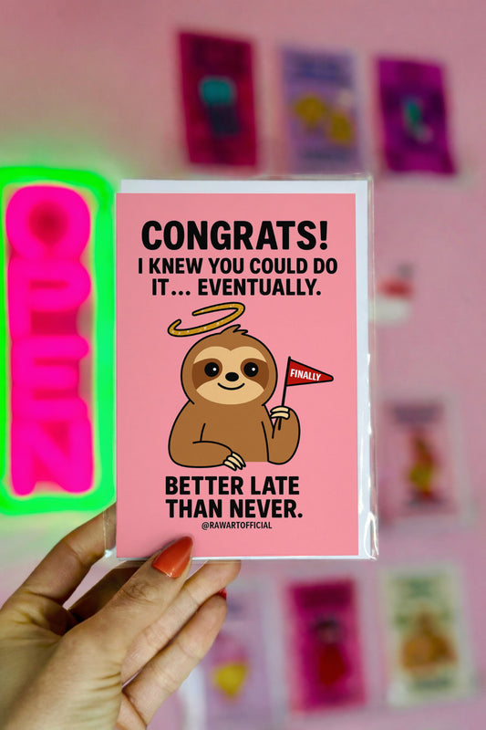 Pink greeting card with a smiling cartoon sloth holding a “Finally” flag and text that says “Congrats! I knew you could do it… eventually.”