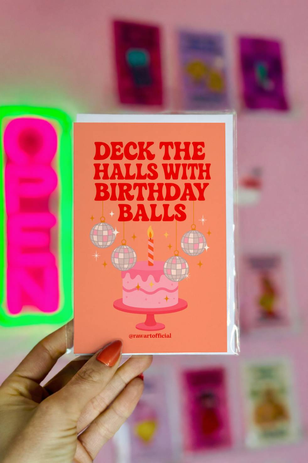 Funny Christmas birthday greeting card featuring a cake with disco ball ornaments and the phrase “Deck the Halls with Birthday Balls.”