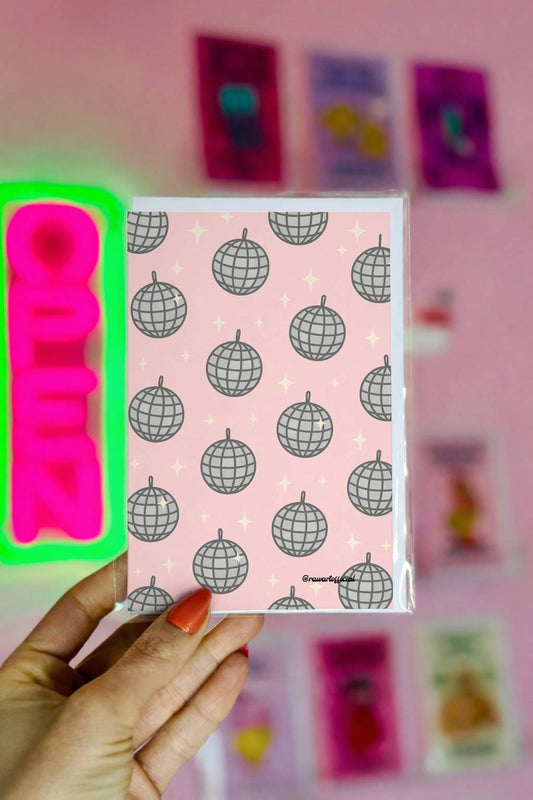 Greeting card featuring a repeating disco ball pattern with silver mirrored spheres on a pink background with small sparkle accents.