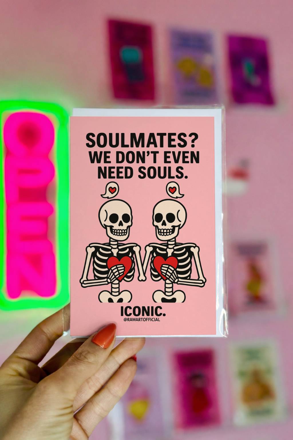 Two skeletons holding hearts on pink background with text “Soulmates? We don’t even need souls.”