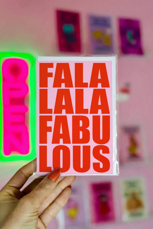 Funny Christmas greeting card featuring bold red retro typography reading “Fa La La Fabulous” on a light pink background.