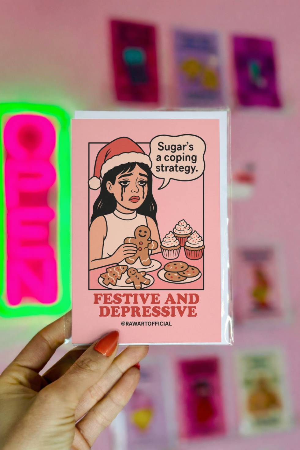 Funny Christmas greeting card featuring a retro comic-style woman in a Santa hat surrounded by cookies and cupcakes with the text “Festive and Depressive.”