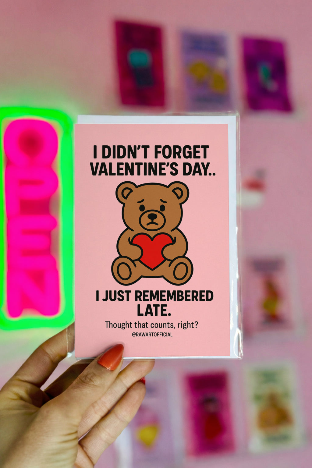 Cute teddy bear holding heart on pink background with text about remembering Valentine’s Day late.