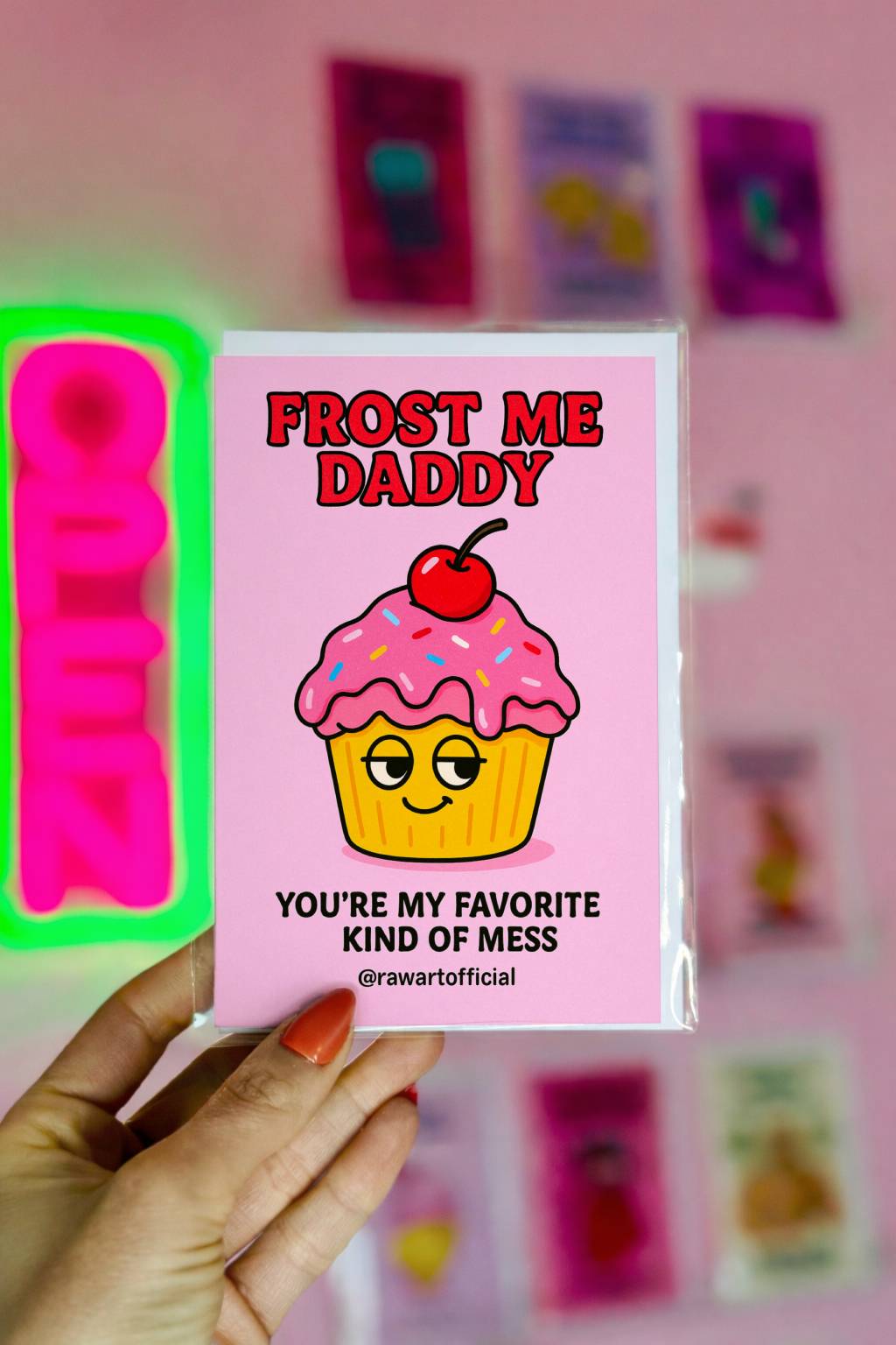 Pink greeting card reading Frost Me Daddy with flirty cupcake illustration and @rawartofficial signature.