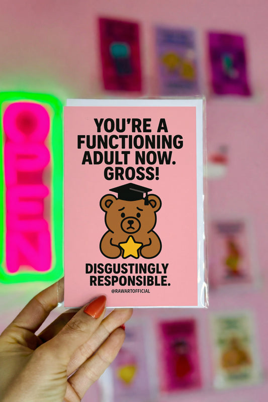 Pink graduation card with sad bear in cap holding a star and bold text saying “You’re a functioning adult now. Gross.”