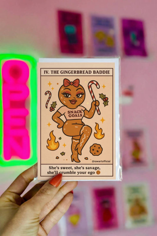 Funny Christmas card featuring “The Gingerbread Baddie” tarot-style cookie character holding a candy cane with text “She’s sweet she’s savage she’ll crumble your ego.”