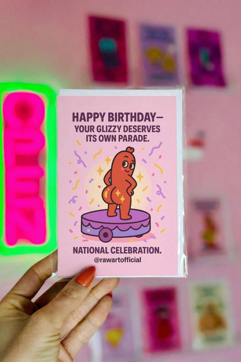Funny birthday card with a cartoon hot dog character standing on a parade float surrounded by confetti and sparkles