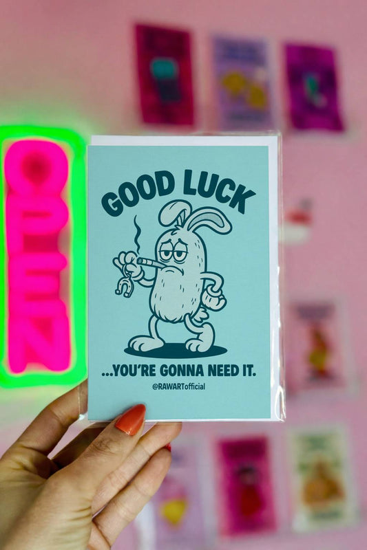 Greeting card featuring a grumpy cartoon rabbit holding a bent horseshoe with the text “Good Luck… You’re Gonna Need It.”