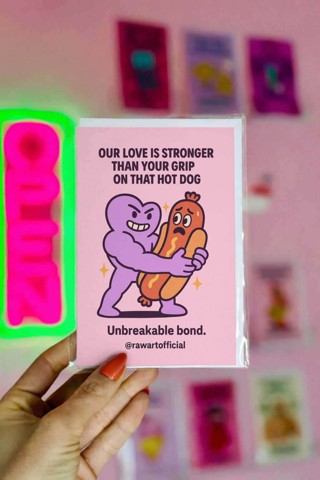 Buff purple heart hugging a scared cartoon hot dog on a pink background, humorous love card by @rawartofficial.