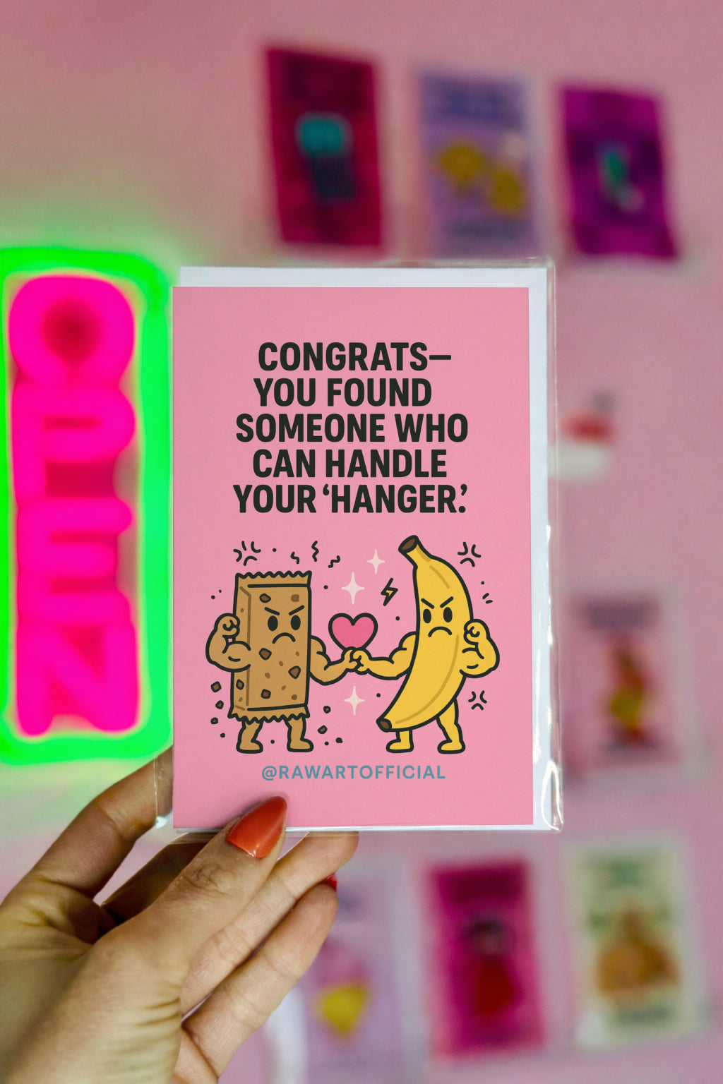 Cute pink wedding card with angry banana and granola bar holding a heart, hanger humor illustration.