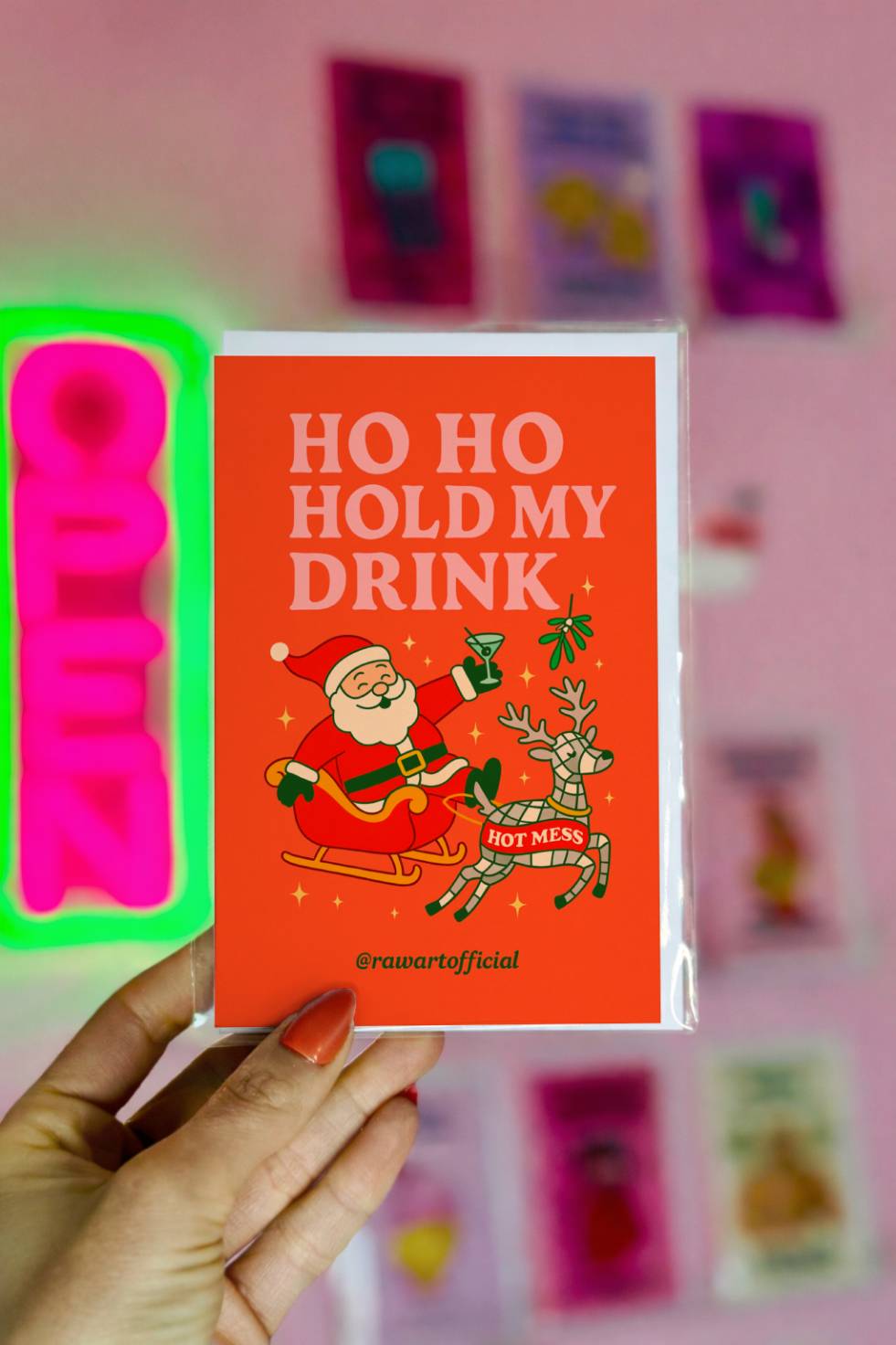 Funny Christmas greeting card featuring Santa holding a cocktail in a sleigh with a reindeer labeled hot mess and the phrase “Ho Ho Hold My Drink.”