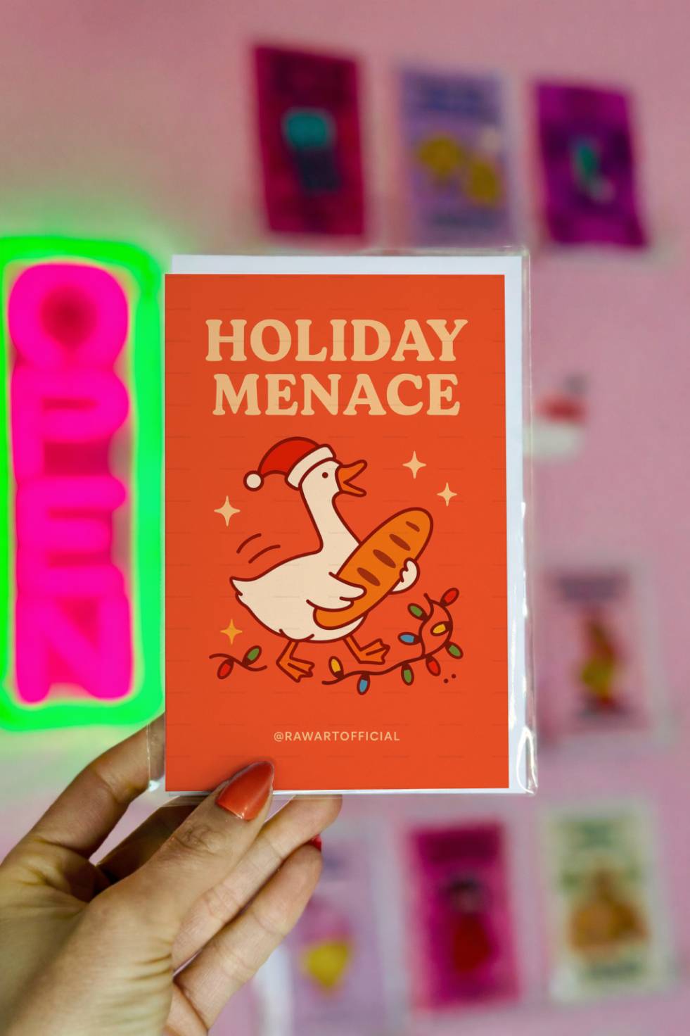 Greeting card with cartoon goose wearing Santa hat holding a baguette with text “Holiday Menace.”
