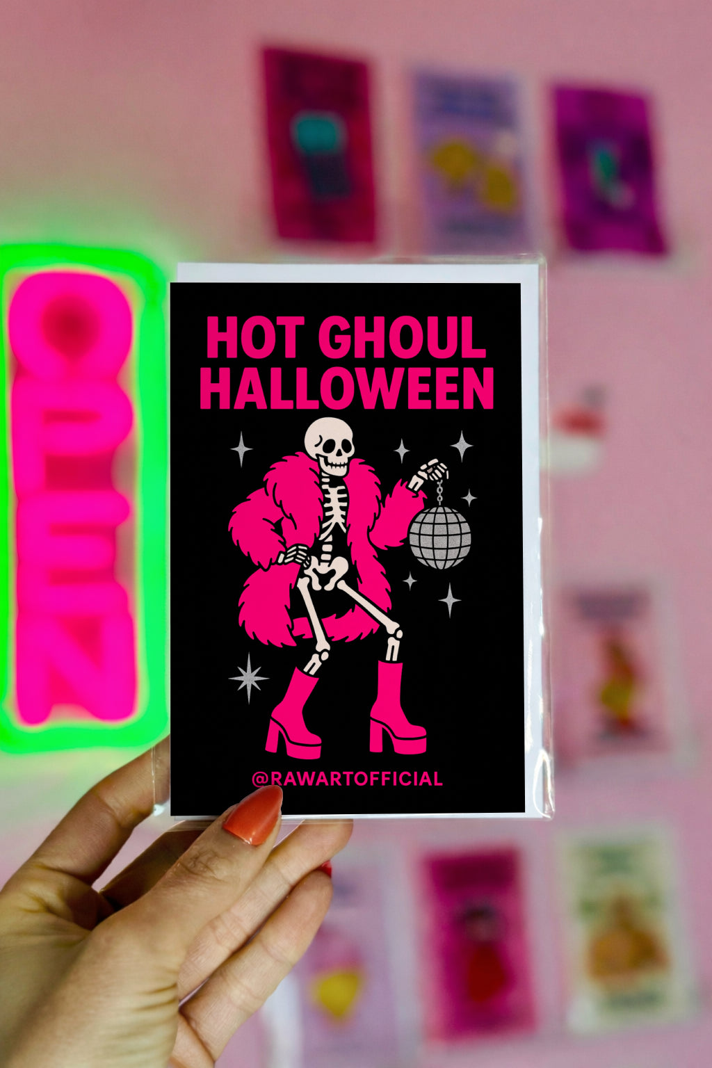 Skeleton in hot pink coat and boots holding disco ball with text “Hot Ghoul Halloween” on black background.