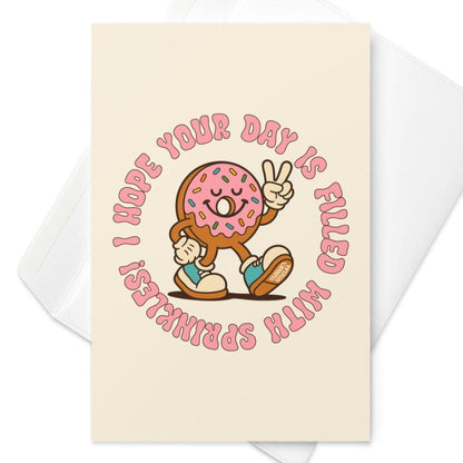Cream birthday card featuring retro pink frosted donut with sprinkles flashing peace sign and circular birthday text.