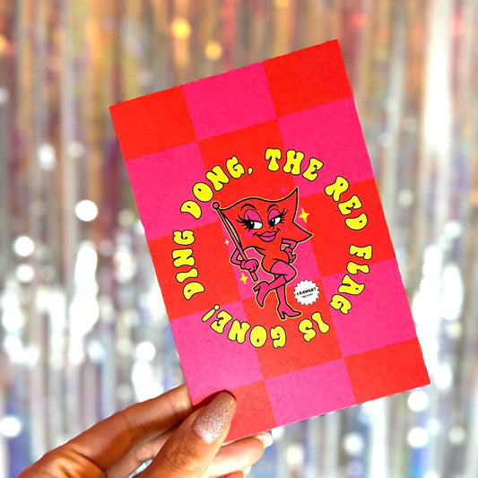 Bold pink and red checkered breakup card featuring a sassy cartoon red flag in heels with text: “Ding dong, the red flag is gone!” Envelope partially shown in the background.