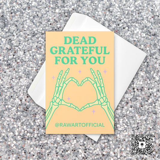 Greeting card with skeleton hands forming a heart and the text “Dead Grateful For You” in pastel green on a peach background.
