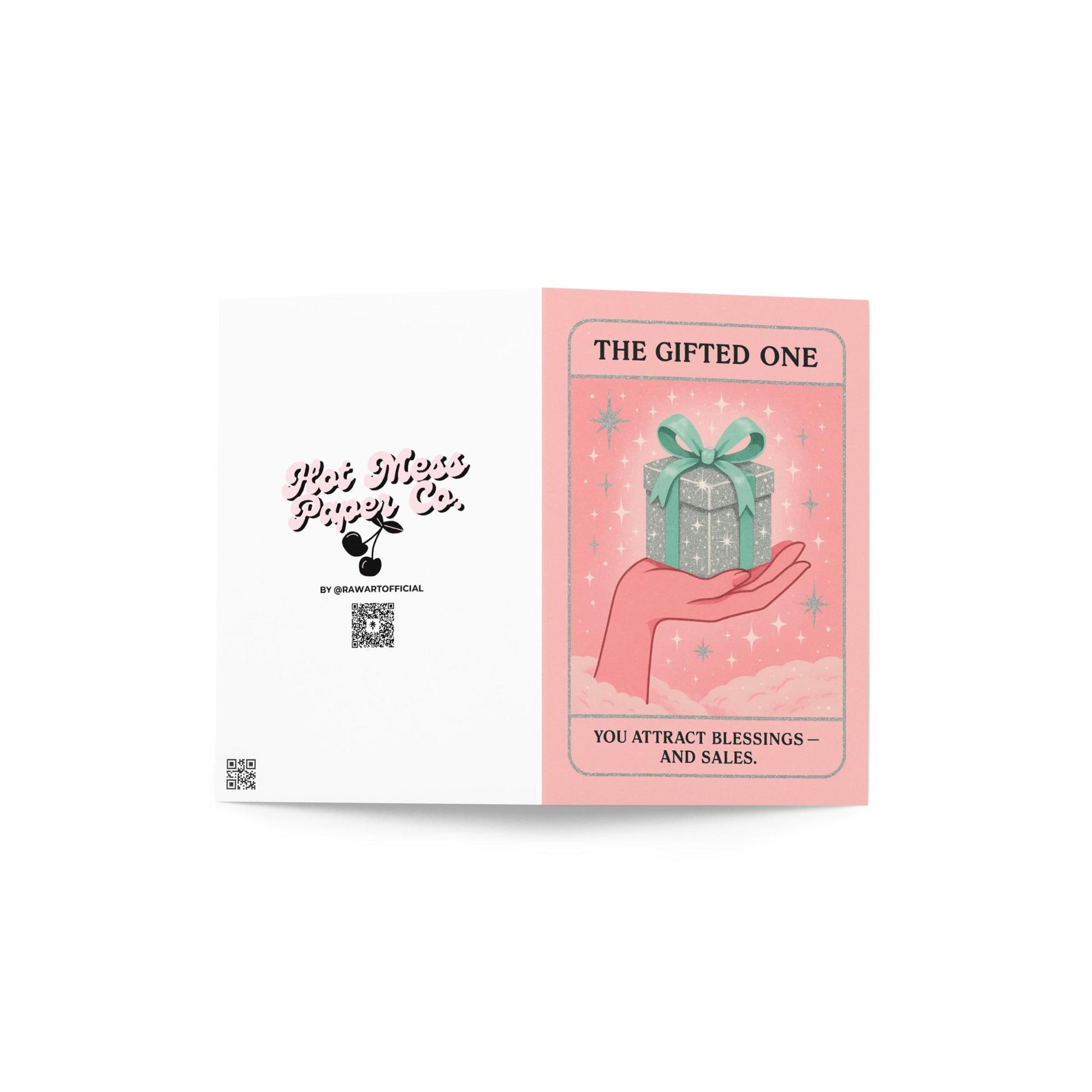 Pastel pink and mint Christmas tarot-style card featuring a sparkling silver gift box with a green bow resting on an illustrated hand, with the text “The Gifted One – You attract blessings and sales.”