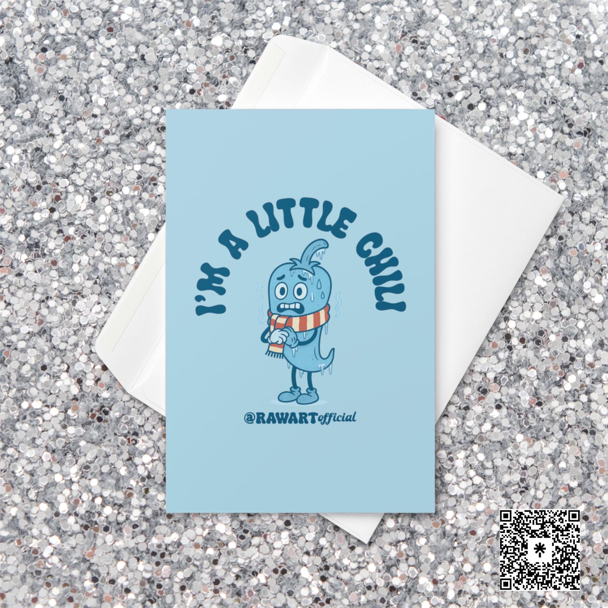 Light blue Christmas card featuring a cartoon chili pepper in a striped scarf with text reading “I’m a Little Chili.”