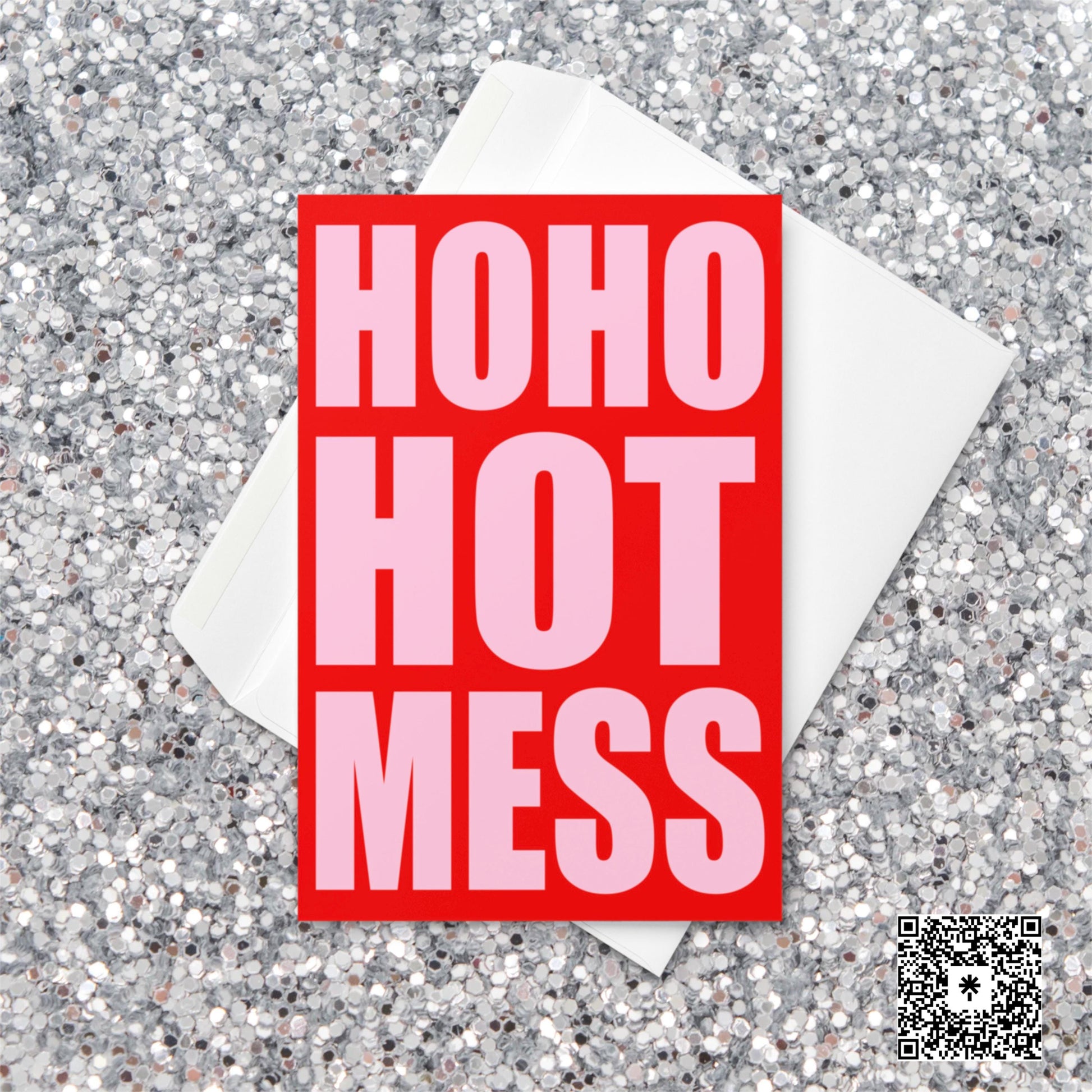 Bright red and pink Christmas card with bold block text reading “Ho Ho Hot Mess” on a glitter background.