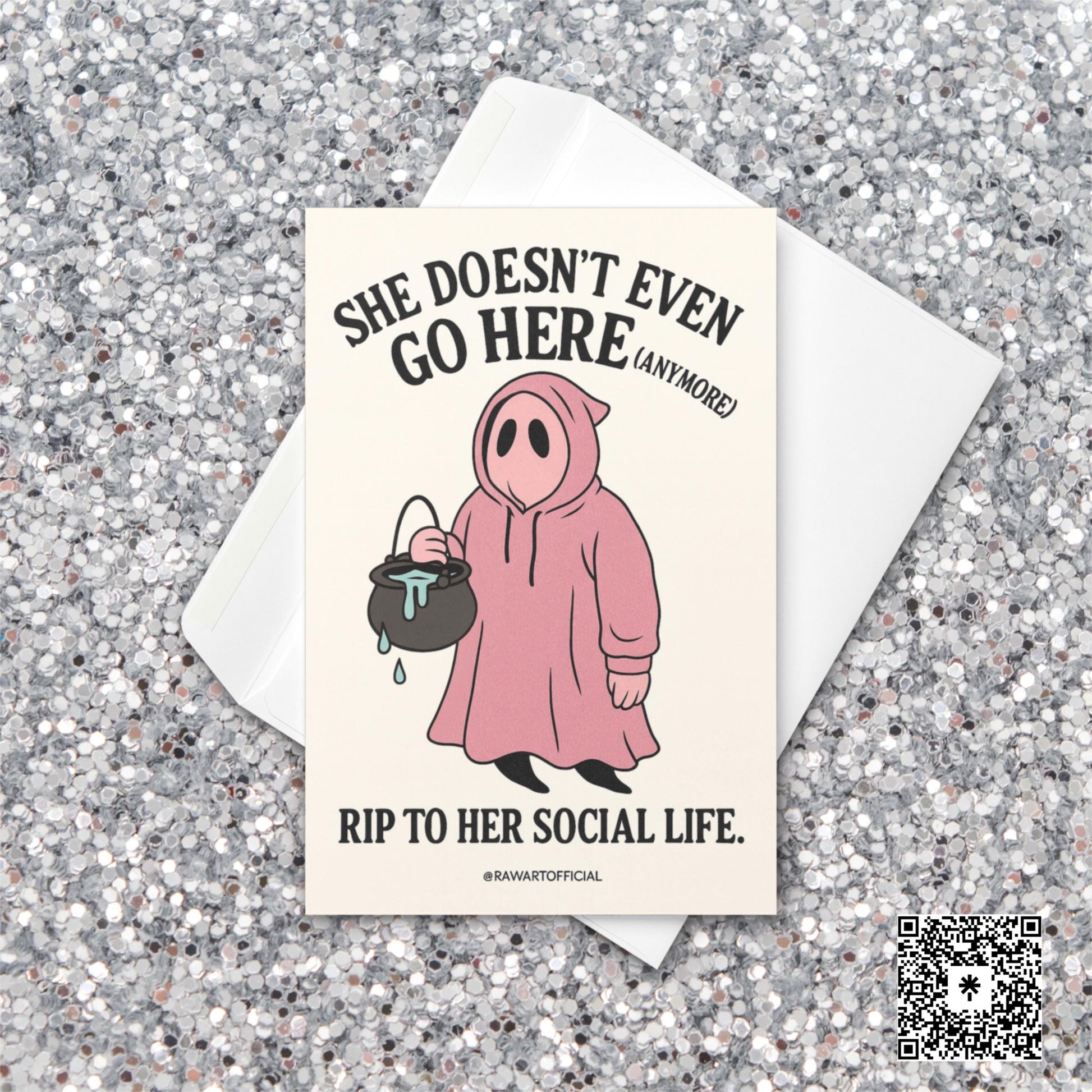 Pink ghost in a hoodie holding a cauldron with text “She Doesn’t Even Go Here (Anymore)” – funny Mean Girls inspired Halloween card.
