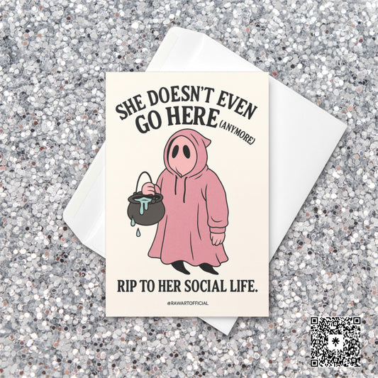 Pink ghost in a hoodie holding a cauldron with text “She Doesn’t Even Go Here (Anymore)” – funny Mean Girls inspired Halloween card.