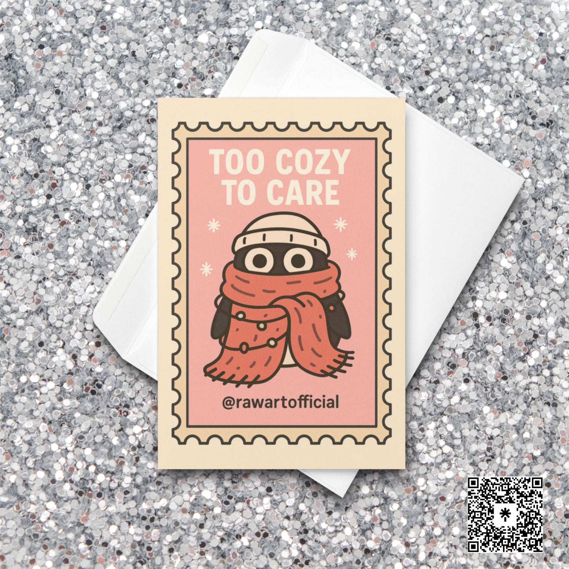 Stamp-style pink holiday card with bundled penguin wearing scarf and beanie, caption reads “Too Cozy To Care.”