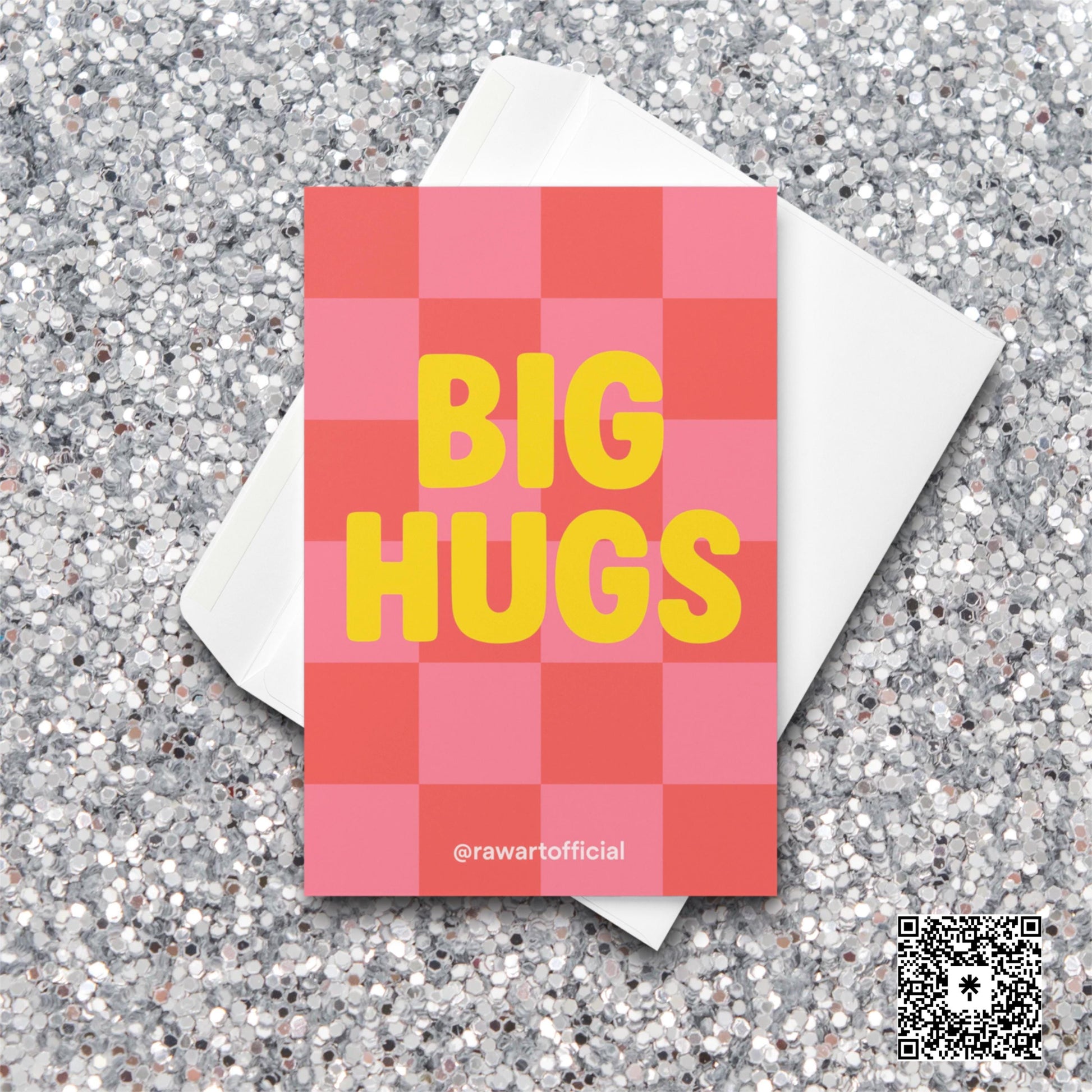 Pink and red checkered greeting card with bold yellow text that says “BIG HUGS.”
