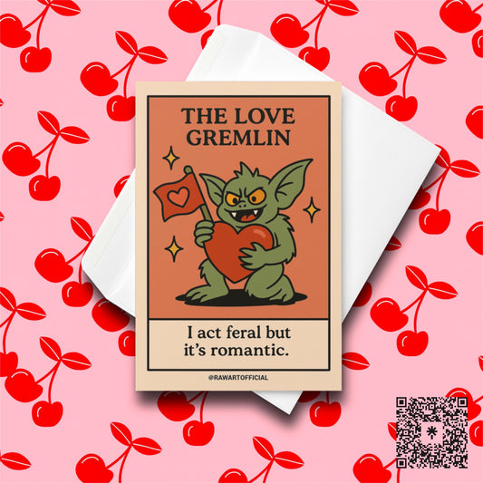 Green gremlin holding a big red heart and love flag with the phrase “I act feral but it’s romantic.”