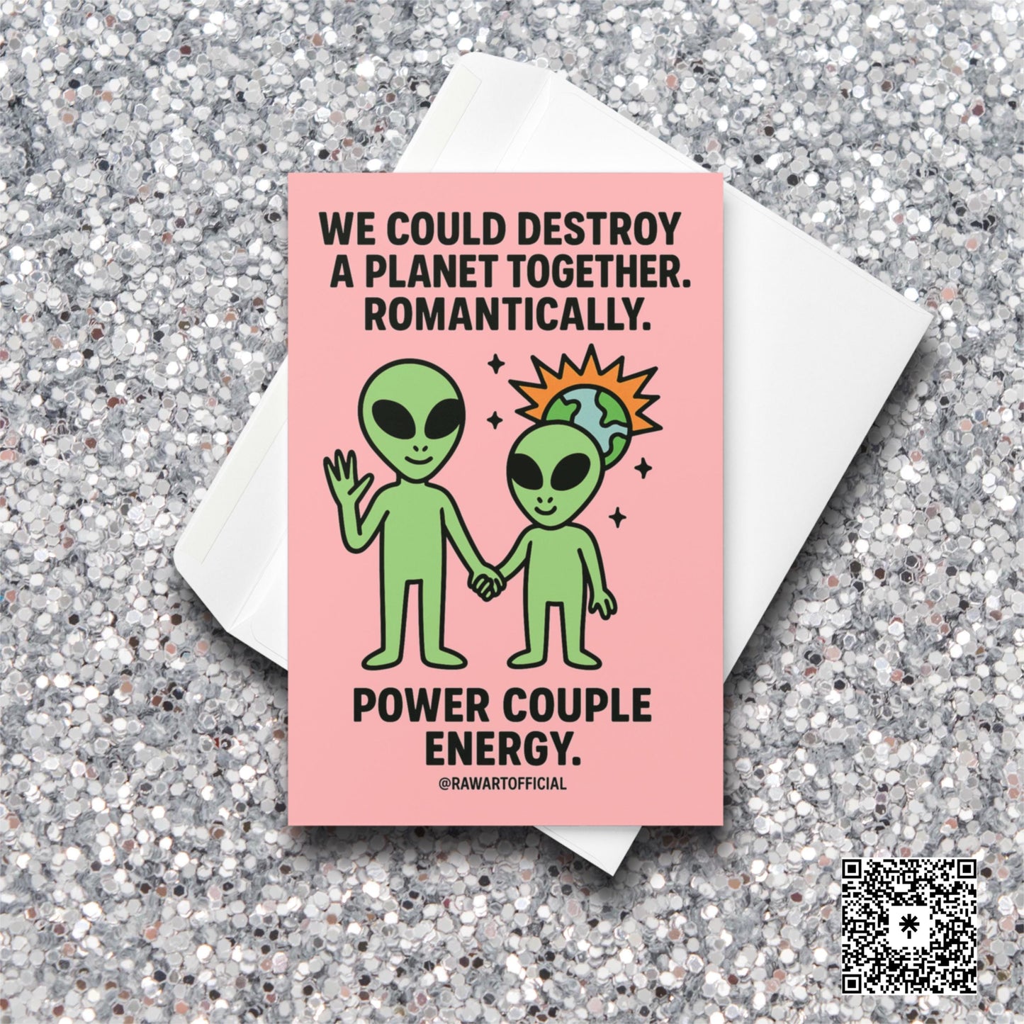Alien couple holding hands with a tiny exploding planet behind them on a pink background. Text says “We could destroy a planet together. Romantically.” Funny Valentine card.