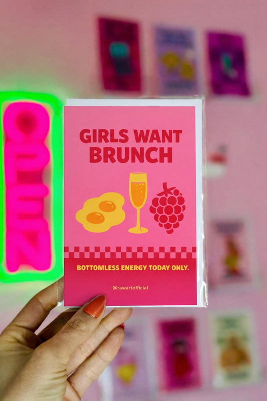 Bright pink birthday card with the phrase “Girls Want Brunch” featuring eggs, a mimosa glass, raspberries, and “Bottomless Energy Today Only.” text.