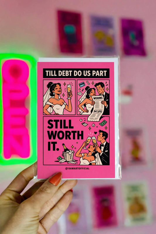 Pink comic-style wedding card reading “Till Debt Do Us Part – Still Worth It” featuring bride and groom celebrating with champagne and wedding bill.