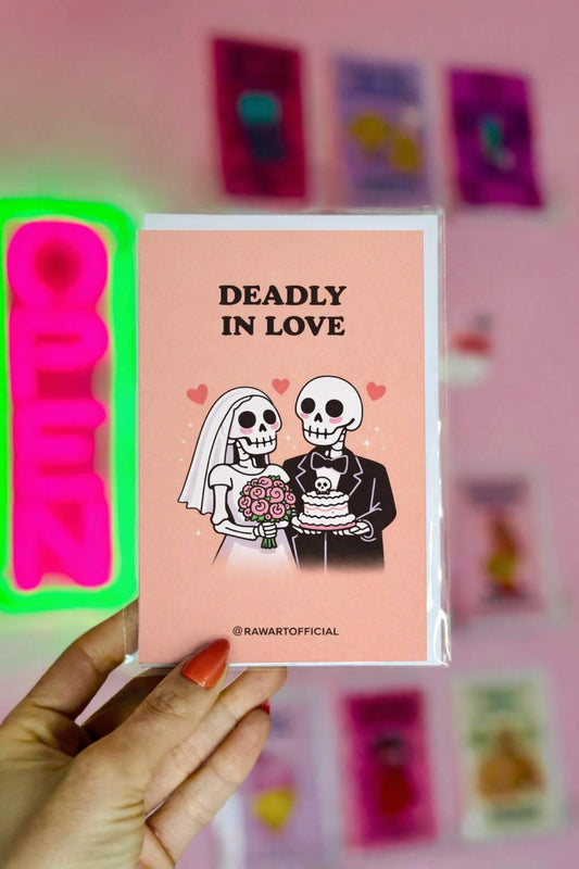 Peach wedding card featuring skeleton bride with bouquet and skeleton groom holding skull cake under text “Deadly in Love.”