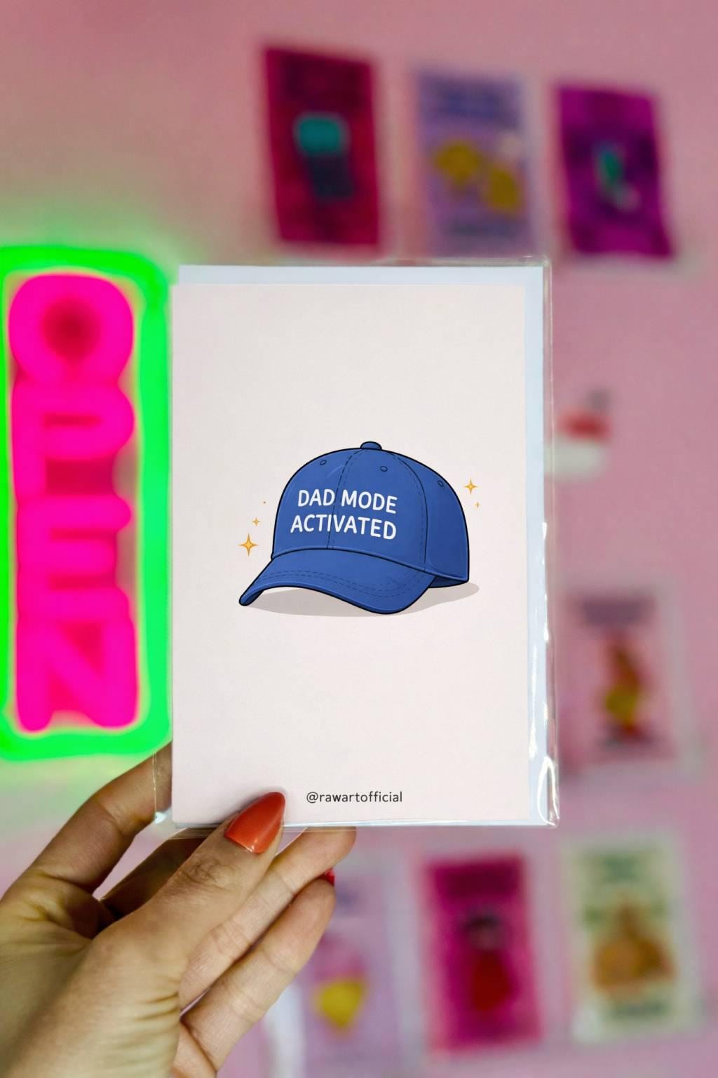 Funny dad greeting card featuring a blue hat that says “Dad Mode Activated” on a clean white background