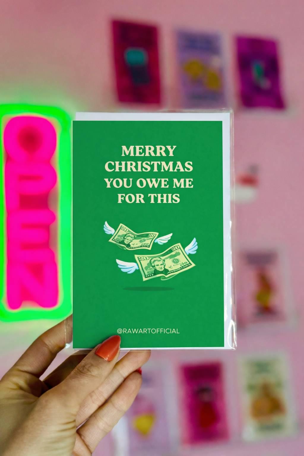 Funny sibling Christmas greeting card with text “Merry Christmas you owe me for this” and flying money illustration on green background