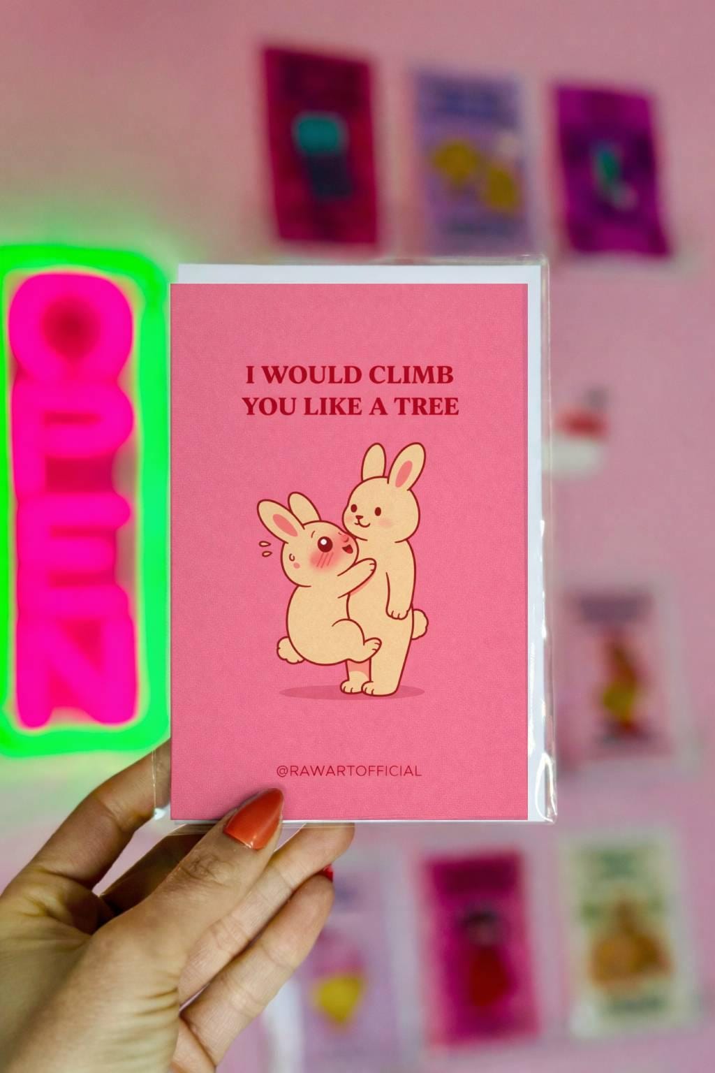 Funny romantic card with two bunnies and text “I would climb you like a tree” on a pink background