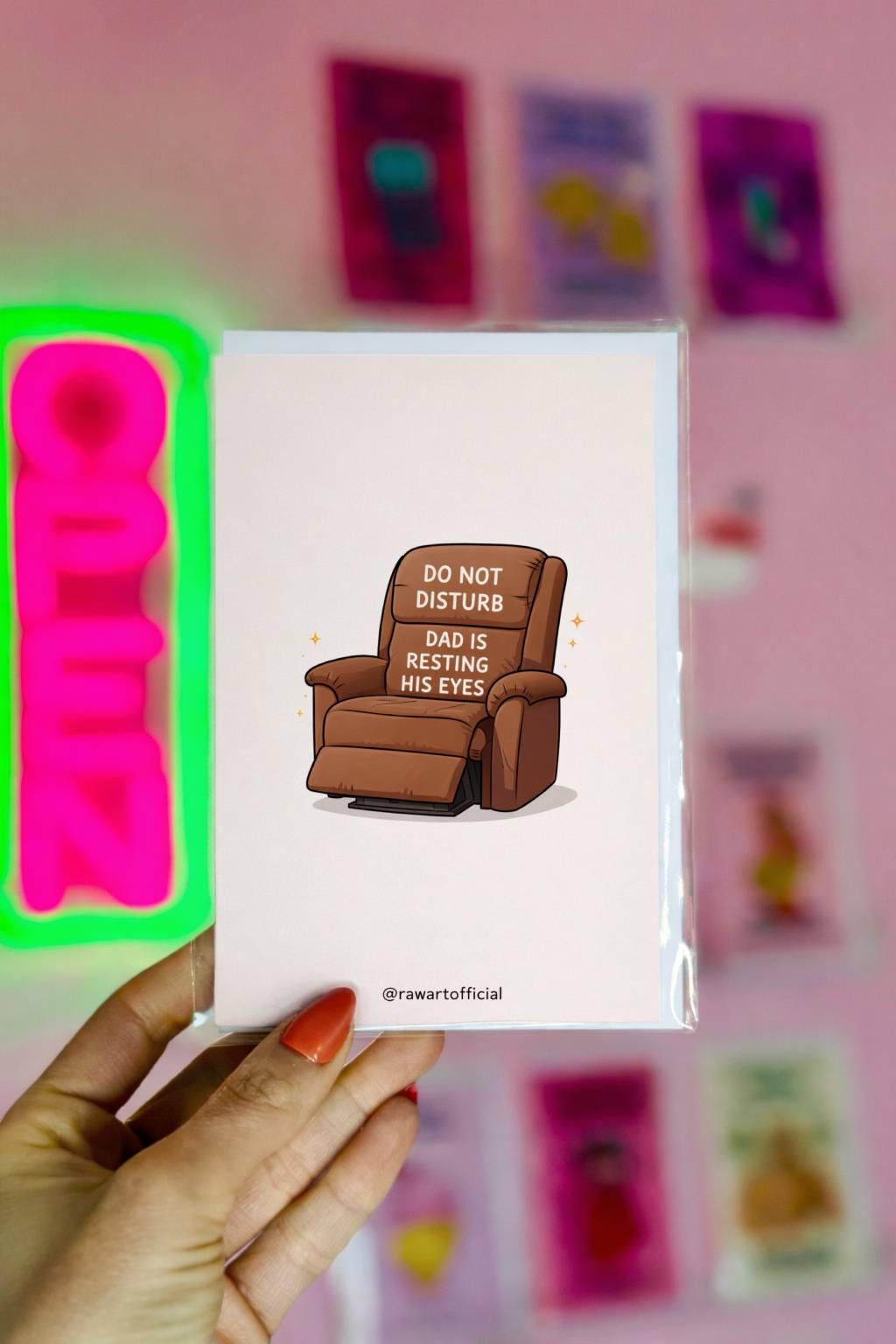 Funny dad greeting card featuring a recliner chair labeled “Do Not Disturb Dad Is Resting His Eyes” on a white background